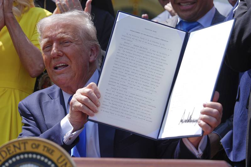 President Donald Trump holds up a signed executive order establishing the Religious Liberty Commission, during a National Day of Prayer event in the Rose Garden of the White House, Thursday, May 1, 2025, in Washington. (AP Photo/Evan Vucci)