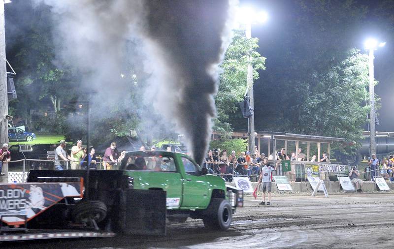The last truck in the Truck and Tractor Pull competition powers down the track during the Kendall County Fair in Yorkville on Saturday, Aug. 6, 2022.