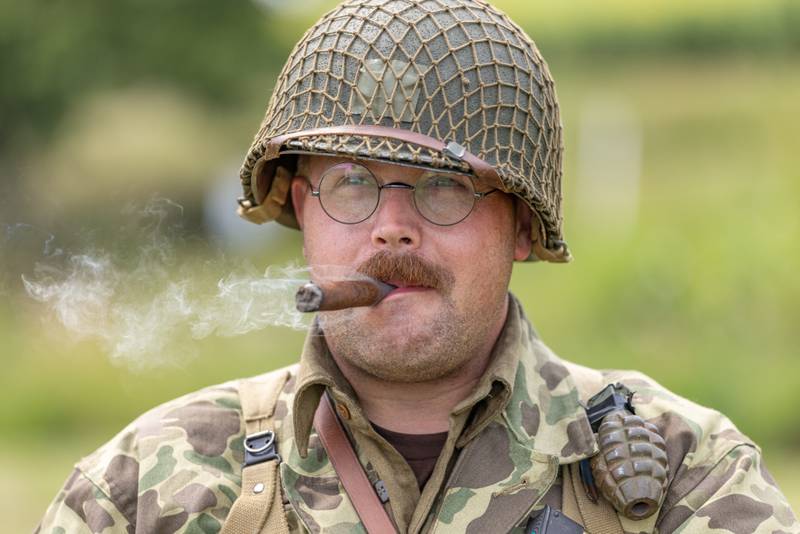 Michael Ralph, an American forces reenactor smokes a cigar prior to going out to the battle demonstration at the Ottawa Military Show on July 13, 2025 in rural Ottawa.