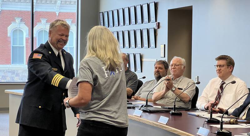 Bart Gilmore shakes Sycamore City Clerk Mary Kalk's hand after being sworn-in as the city's new fire chief on June 5, 2023.