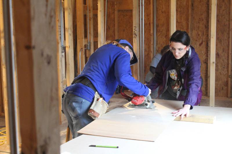 Habitat for Humanity volunteers Pam Spain and Melissa Wagner work on constructing the interior of a home in McHenry.