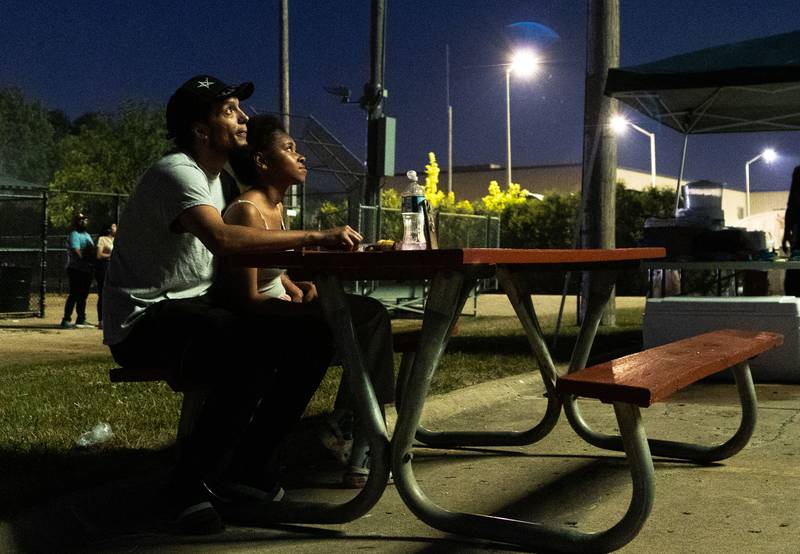 Spectators are illuminated by the “July 4th Fireworks” at Langum Park in St. Charles on Friday, July 4, 2025.
