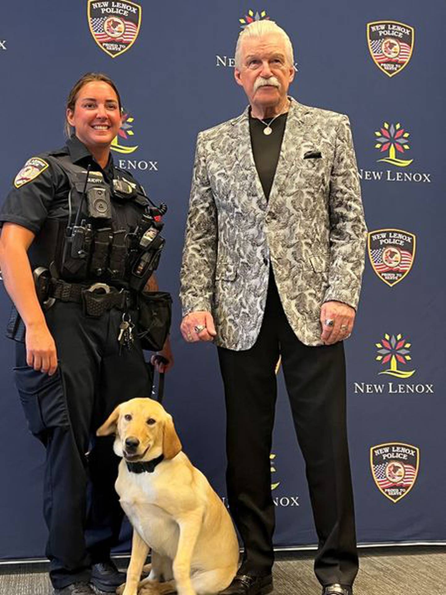 New Lenox Police Officer Candace Guidry with Will County State's Attorney James Glasgow and a police dog named Harlie.