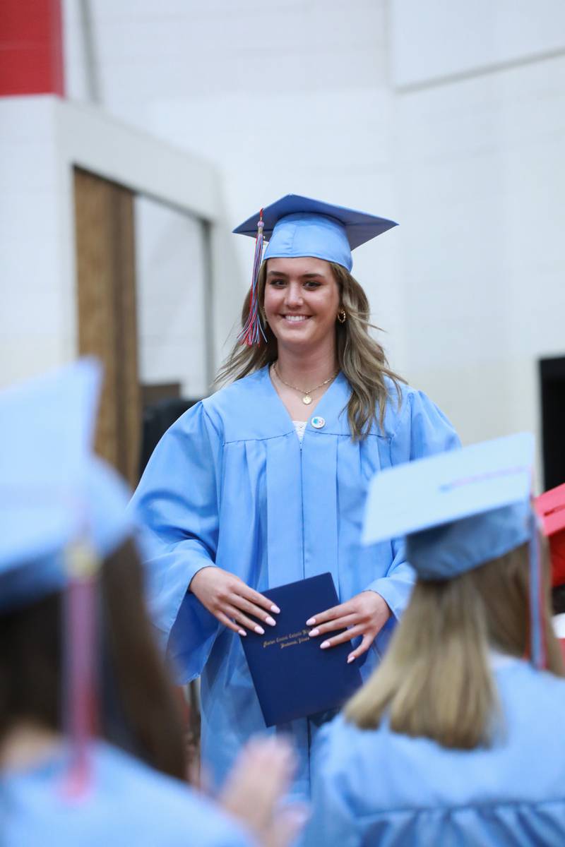 Valle Leggett beams at classmates after receiving her diploma Friday, May 27, 2022, at Marian Central Catholic High School in Woodstock.