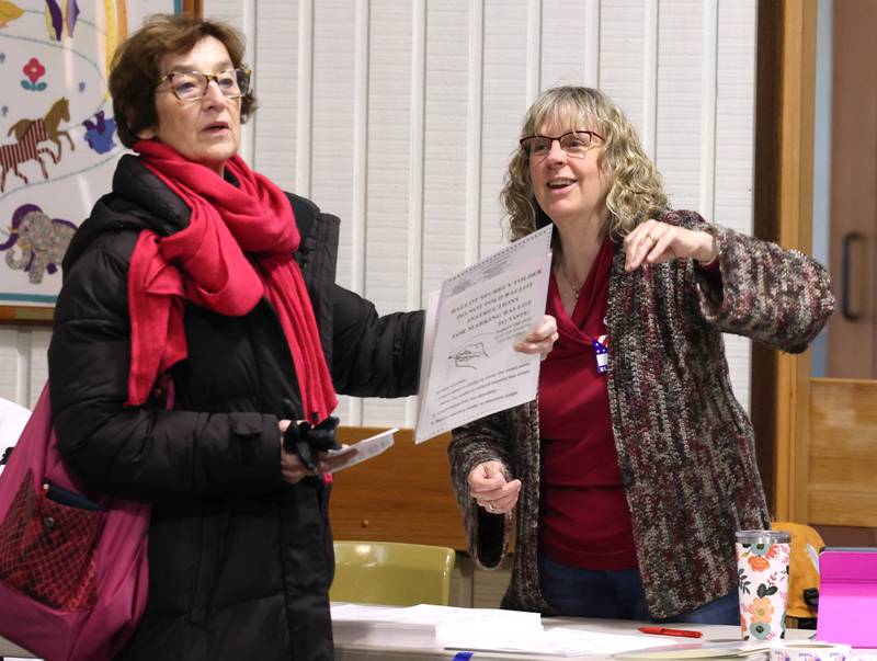 Election judge Claire Duvall (right) helps Catherine Raymond, from Delkalb, find a booth to vote in Tuesday, April 1, 2025, in the polling place at the Westminster Presbyterian Church in DeKalb.