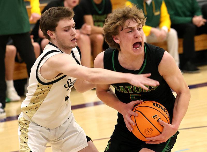Crystal Lake South's Carson Trivellini protects the ball from Sycamore's Preston Picolotti during their sectional semifinal game Tuesday, March 4, 2025, at Rochelle High School.