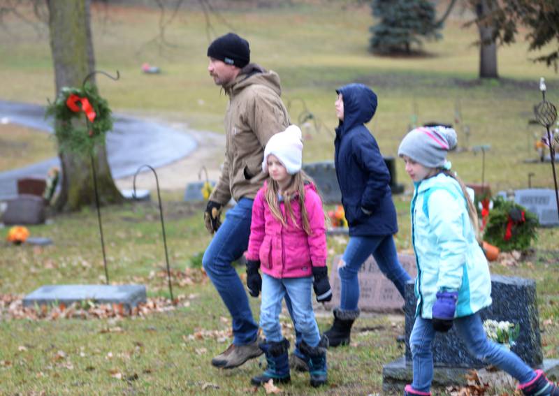 Luke Becker of Oregon, and his daughters Lana, Aven and Remy helped place wreaths at the Wreaths Across America event at Daysville Cemetery. east of Oregon, on Saturday, Dec. 16, 2023.