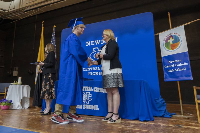 Newman graduate Payton Hanna accepts his diploma Wednesday, May 21, 2025, during commencement.