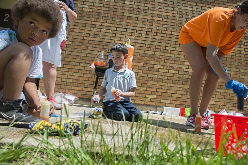 Dixon St. Anne’s School second grader Alex Brown (middle) and first grader Maxwell Lumzy (left) apply tie-dye to shirts Friday afternoon as part of a STREAM (Science, Technology, Religion, Engineering, Art, Mathematics) fun day at the school. The shirt project was made possible by a grant in memory of Judge Martin Hill.