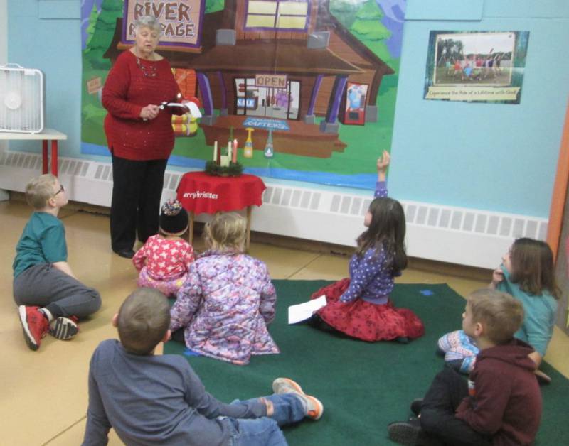 Sunday School students at the United Methodist Church of Plano look on as teacher Gerri Henze  gets ready to light the second candle on the Advent Wreath.