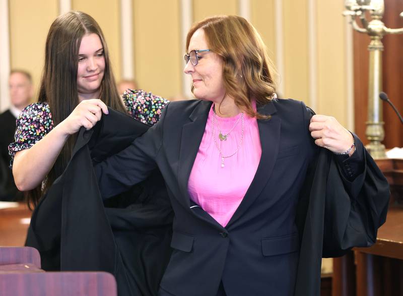 Judge Jill K. Konen is presented with her robe by daughter Amelia after being sworn in as an associate judge of the 23rd Judicial Circuit Friday, Sept. 23, 2022, at the DeKalb County Courthouse in Sycamore.