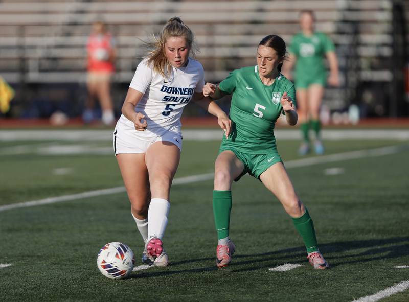 Downers Grove South's Sienna Thurston (5) fights for the ball against York's Julia Clink (5) during the Class 3A Morton regional girls soccer final between Downers Grove South and York in Berwyn on Friday, May 17, 2024.