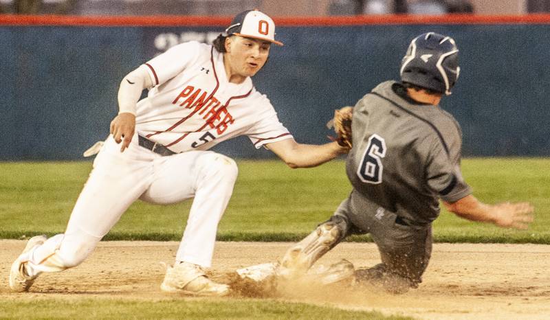 Oswego shortstop Ethan Valles (5) tags out stealing Oswego East runner Liam Mitchell during a varsity boys baseball game on Thursday, May12, 2022 at Oswego High School.