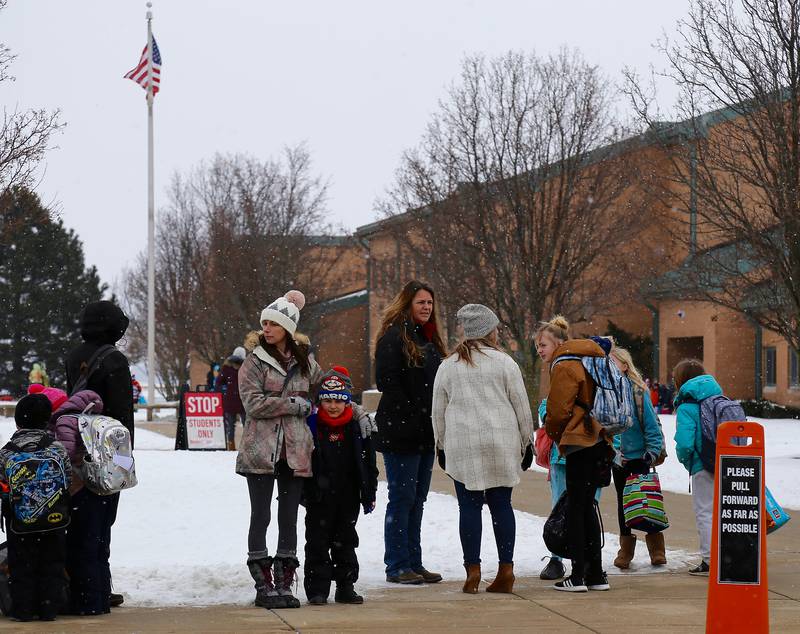 A group of parents who don’t want their children wearing masks gather before school starts at Kaneland John Stewart Elementary School in Elburn on Monday, Feb. 7, 2022.