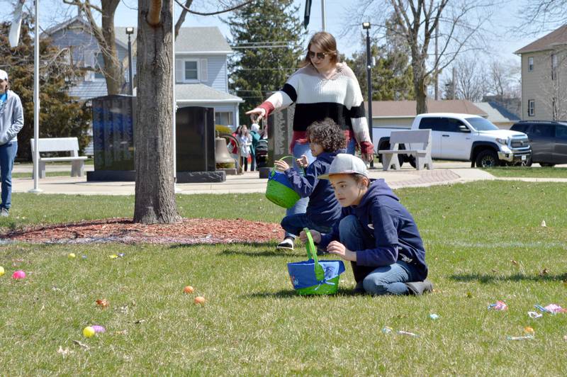 Dashad Howard, 9, front, participates in a sensory sensitive Easter egg hunt in Forreston's Memorial Park on April 8, 2023. Behind Dashad, his aunt, Alyssa Vinnedge, points his brother, Antwon Howard, 7, toward more prizes. The Forreston Lions Club and Forreston Area Business Association sponsored the annual Easter egg hunts and a Touch-A-Truck event. The sensory sensitive egg hunt was new this year.