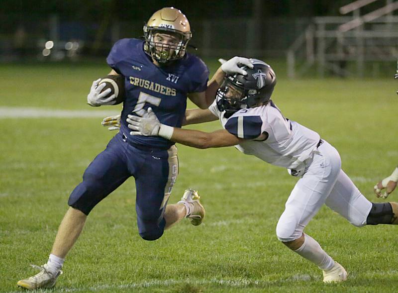 Marquette's Tommy Durdan (5) stiff arms Wethersfield's Mason Heitzler during a carry on Friday, Sept. 16, 2022 at Gould Stadium in Ottawa.