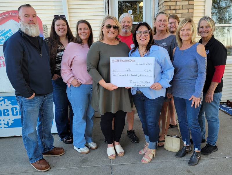 OSF St. Elizabeth nurse Yvette Baiz (front, right) presents to Women Inspired Network Fundraiser Committee lead Carol Kuzmich a check for $2,500 to go toward the Young Women Leaders Scholarship Fund. That donation brings the total raised by the “Girls Just Want To Have Fund$” golf outing to $14,000. Also present were (from left) event staff James Wilson, committee members Bethany Lamb and Sarah Fox and staff Bob Bradish, Jeanne Lindenmuth, Bobby Bradish and Karen Habben. Absent were committee members Janice Corrigan, Jane Goetz and Fran Brolley and staff Erika Mucci and Lauren Mucci.