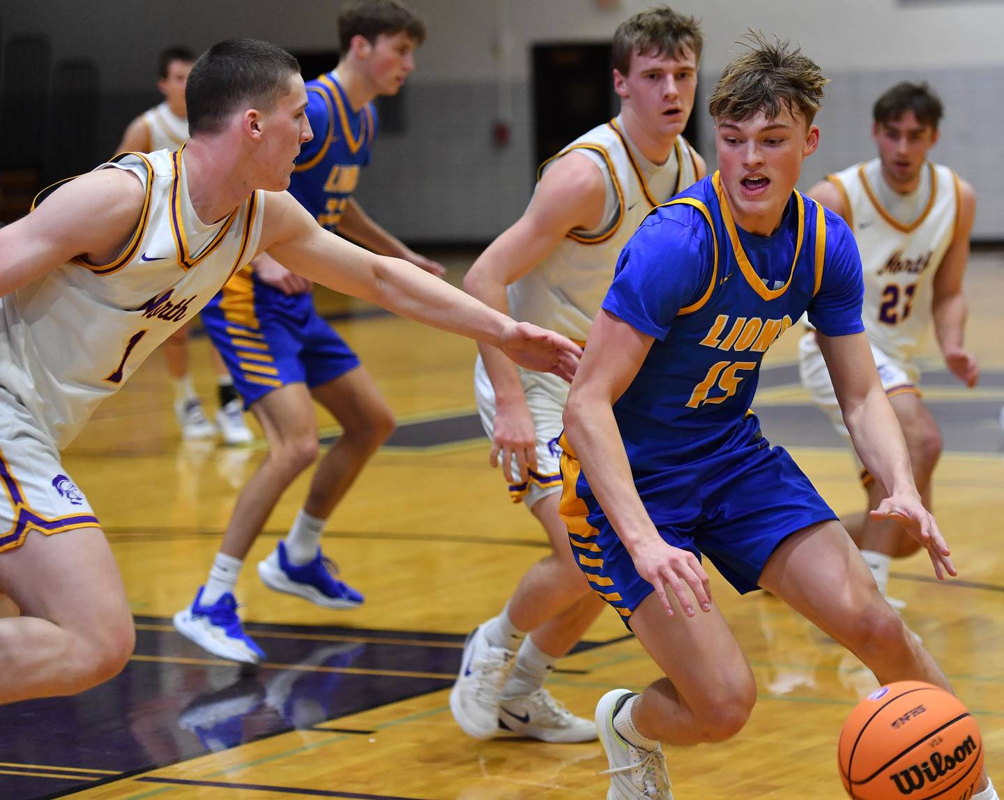 Lyons Township’s Lyons Township’s Timmy Sloan (15) drives as Downers Grove North’s Colin Doyle (left) defends during a game on January 15, 2026 at Downers Grove North High School in Downers Grove .