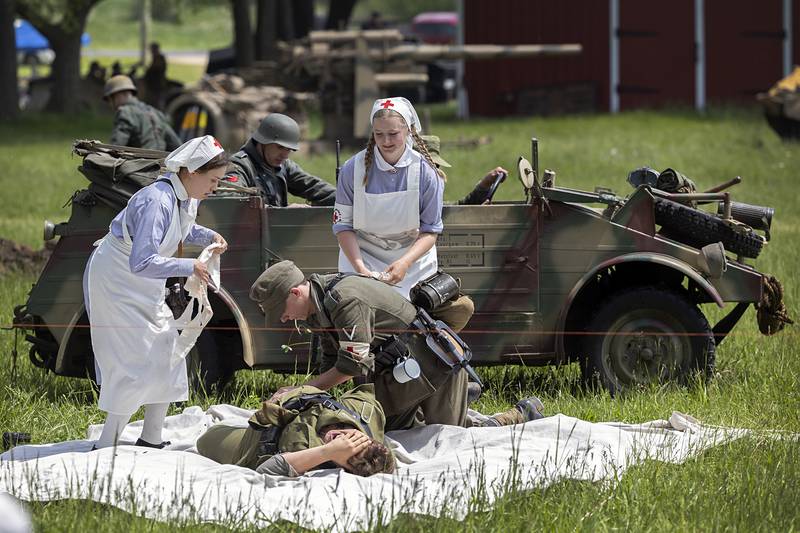 Medics tend to a victim Saturday, May 16, 2026, during a reenactment of the Battle of Anzio in Franklin Grove.