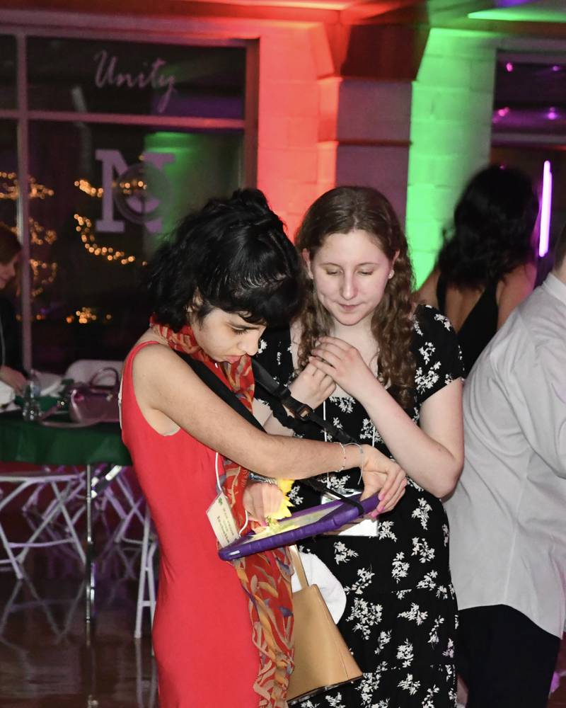Isabella uses an iPad to communicate with her buddy Evelyn Rosenberg during the 7th FISH Prom for Teens with Disabilities on Saturday, March 8, 2025 at Nazareth Academy in La Grange Park.