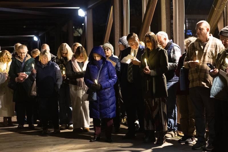 Locals gather with area faith leaders for a candlelight vigil at the Peace on Earth Bridge as part of an International Peace Vigil on Sunday, Nov.23, 2025, in Batavia.