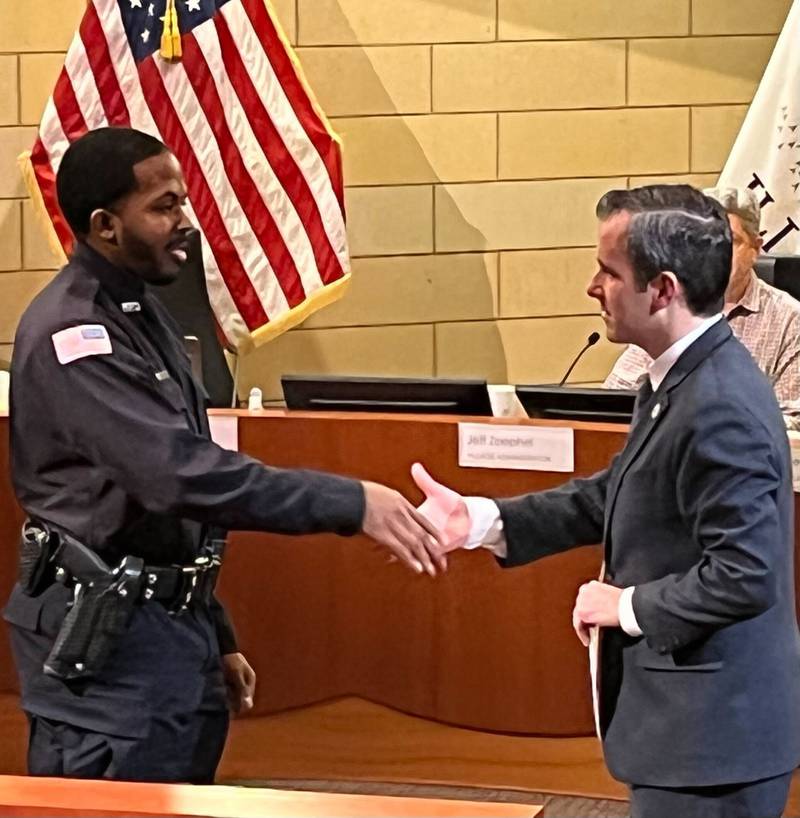 Montgomery Village President Matt Brolley congratulates Damion Woods, left, on his swearing-in as a village police officer during a Village Board meeting Monday, Jan. 23, 2023 at Village Hall.