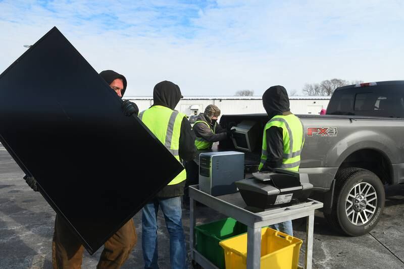 Workers carry electronic items from the back of a truck during the residential electronic recycling event offered by Ogle County Solid Waste Management Department in Oregon. Ogle County residents must pre-register for the free collection event scheduled for Friday, March 25.