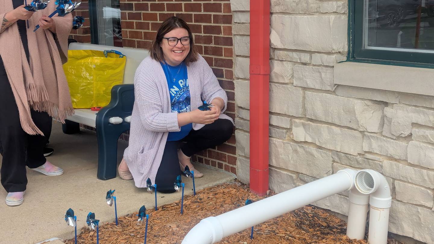 Dorothy Kruczek, a trauma therapist at the Will County Children’s Advocacy Center in Crest Hill, plants blue pinwheels outside the center on Tuesday, April 1, 2025.