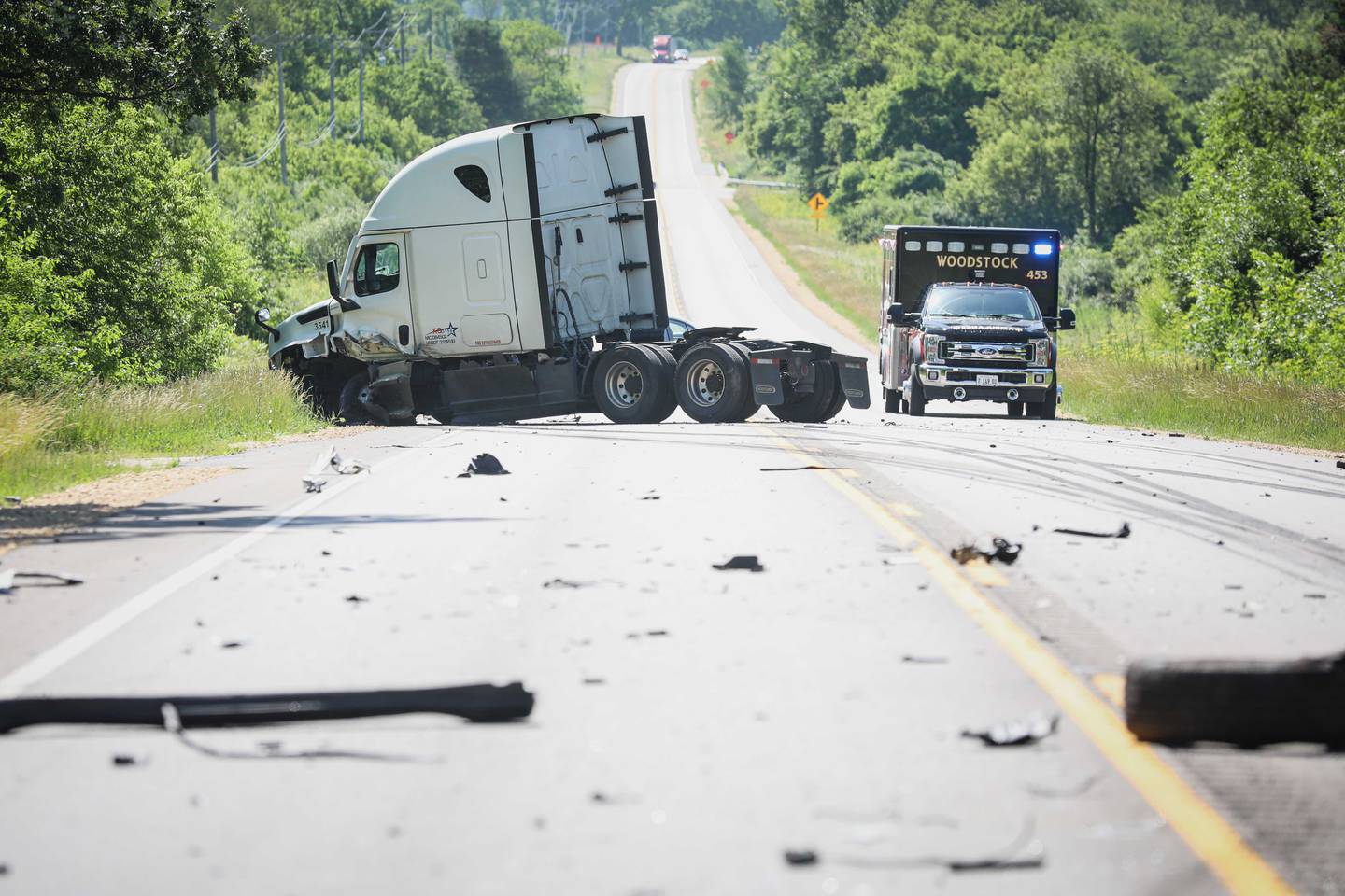 The aftermath of a crash between a semi and a car is shown on Monday, June 23, 2025 along Route 14 outside Woodstock.