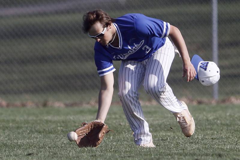 Woodstock’s Kaden Perkins losses his cap as he fields the ball during a Kishwaukee River Conference baseball game against Woodstock North Tuesday, April 18, 2023, at Emricson Park.
