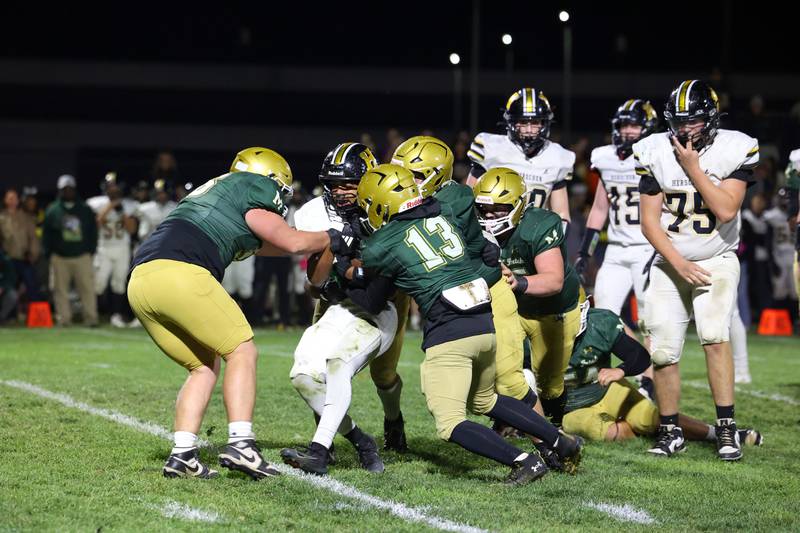 Bishop McNamara defenders stop Herscher's Alek Draper during Bishop McNamara's 38-14 victory in the IHSA Class 3A first round playoff game on Friday, Oct. 31, 2025.