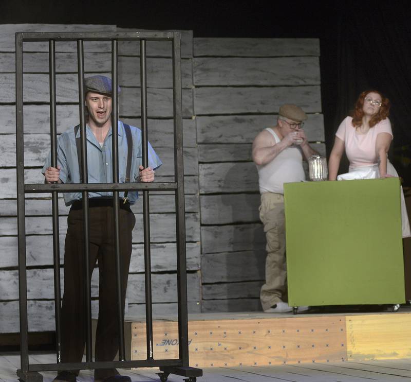 Jake Jakielski (left), as Clyde Barrow, protests his incarceration while Michelle Hainline (right) as Bonnie Parker waits on John, played by Chris Kelley during rehearsals of “Bonnie & Clyde” at Stage 212 in La Salle. The musical, which runs Feb. 2-4 and Feb. 9-11, is based on the real-life bank robber-killers and is not considered suitable for young audiences.