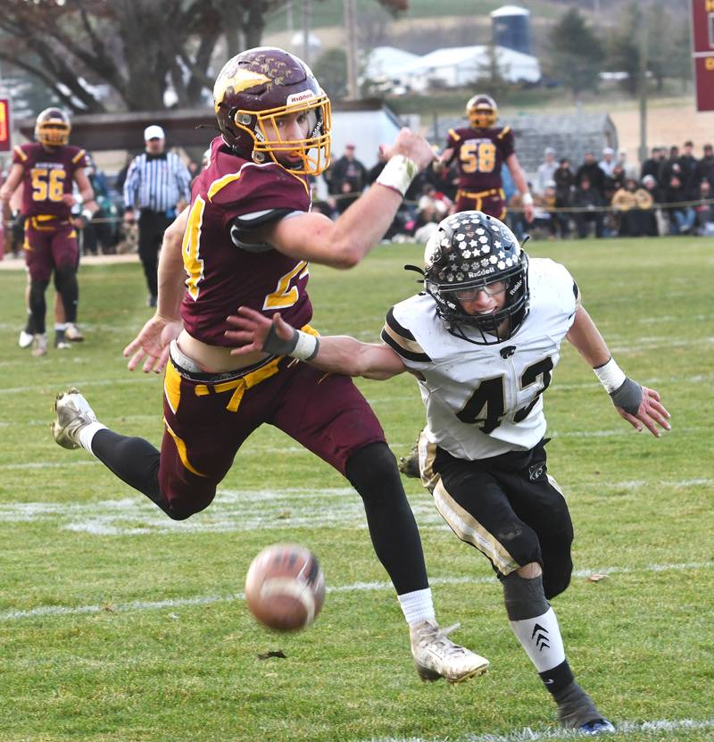 Stockton's Jack Mensendike (24) reaches for a pass as Lena-Winslow's Alec Schlichting (43) defends in 1A semifinal action in Stockton on Saturday, Nov. 22, 2025.