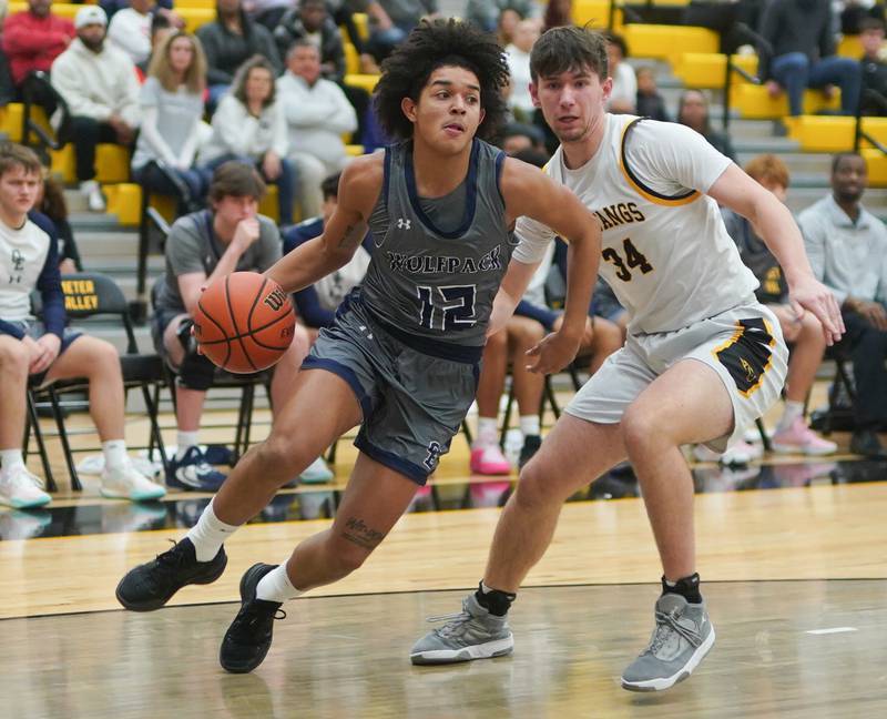 Oswego East's Drey Wisdom (12) drives the baseline against Metea Valley's Connor Lavery (34) during a basketball game at Metea Valley High School in Aurora on Wednesday, Dec 20, 2023.