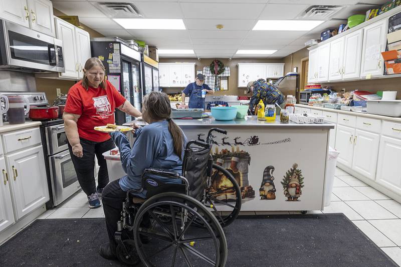 Barb Brady dishes up a meal Wednesday, Jan. 7, to a Sterling PADS client. Barb and husband Mike volunteer to cook at the shelter two times a month. When they started 12 years ago there was only one person utilizing the shelter; on Wednesday there were nearly 20 clients.