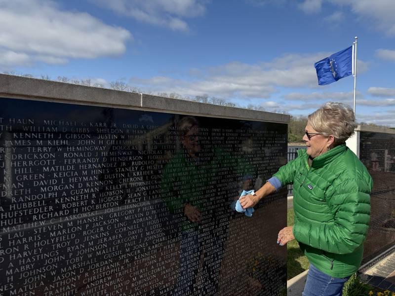 Volunteer Janet Rakes washes and cleans one of the walls Saturday, April 25, at the Middle East Conflicts Wall Memorial in Marseilles.