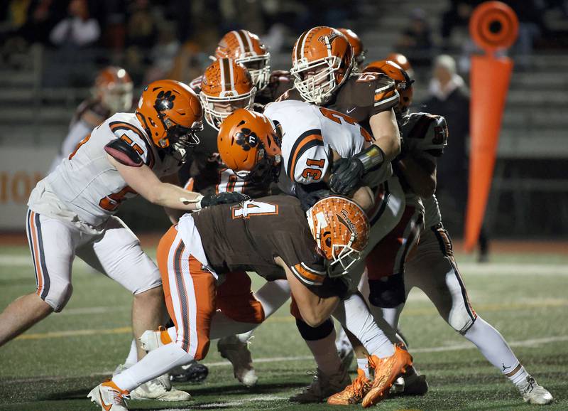 Wheaton Warrenville South's Matthew Crider (31) is wrapped up by a host of Hersey players during the IHSA Class 7A playoffs Saturday October 28, 2023 in Arlington Heights.