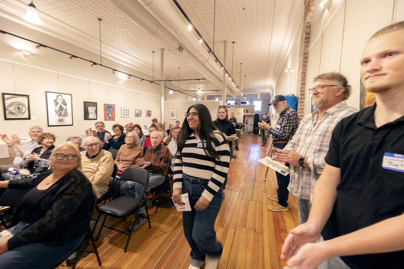 Denia Rincon, senior at Rochelle High School, accepts her second place award for her mixed media piece titled “Intro to Education,” Friday, March 28, 2025, at The Next Picture Show’s student art exhibit.