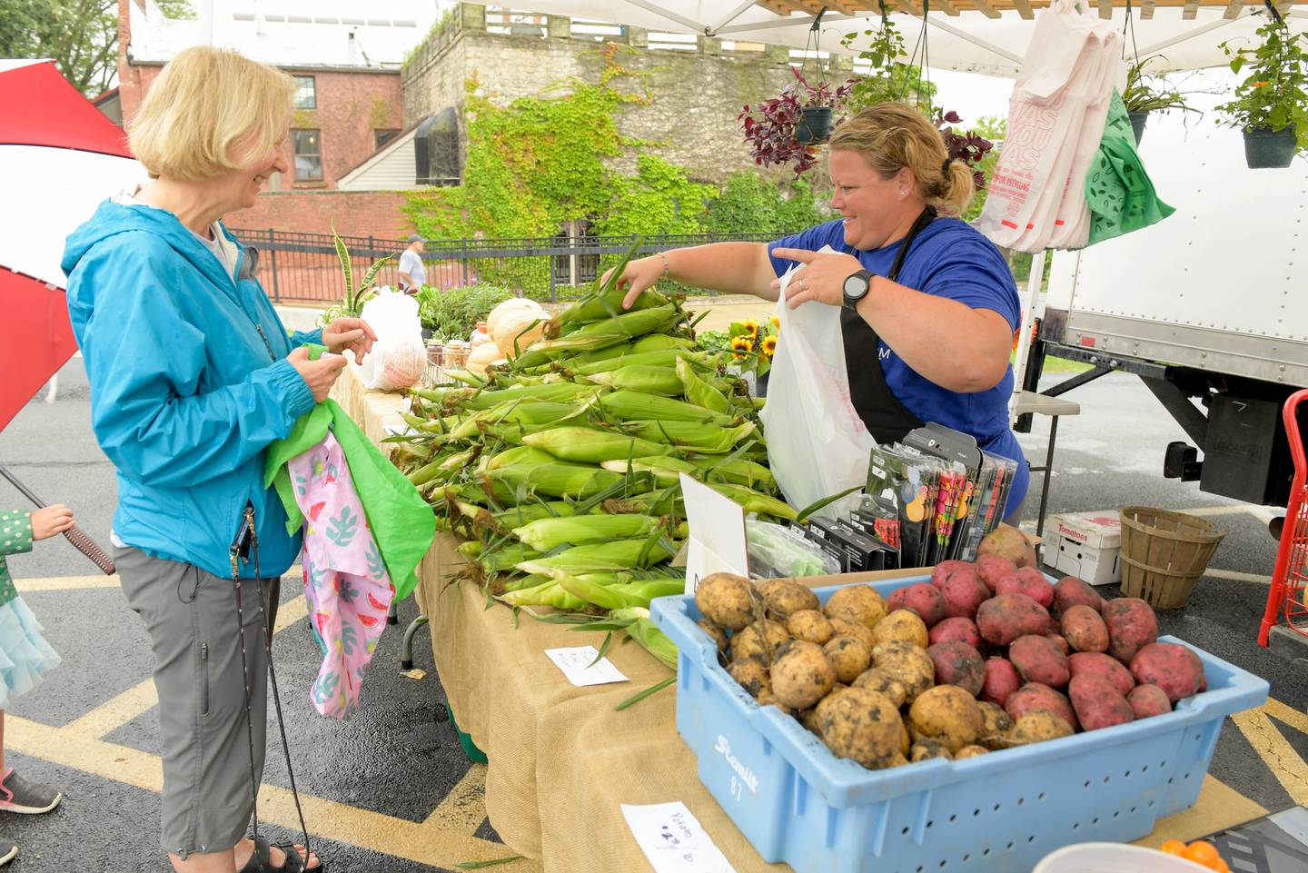 Linda Mahler of Batavia purchases some fresh corn from Danielle Stojan of Stojan’s Family Farm in Maple Park during the Batavia Farmers' Market on Saturday, August 5, 2023.