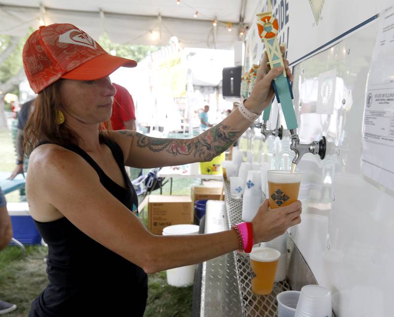Jenny Havens of Crystal Lake Brewing Company pours a beer Friday, July 1, 2022, during Lakeside Festival at the Dole and Lakeside Arts Park, 401 Country Club Road in Crystal Lake. The festival continues noon to 11 p.m. July 2 and noon to 10 p.m. July 3. The festival features bands on two outdoor stages, food and drinks, a baggo tournament, and carnival rides and games. Among the activities for kids are face painting, a balloon twister, a stilt walker, team mascots and a magician.