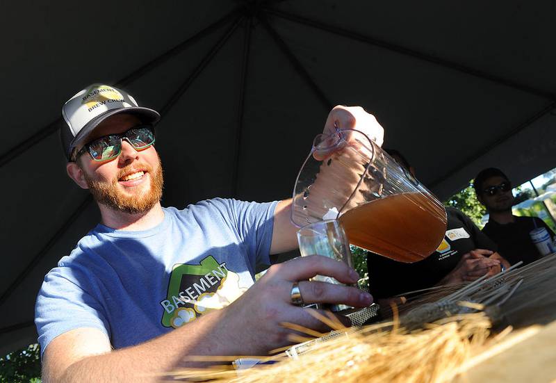 Andrew Foote of Basement Brew, a group of home brewers based in Oswego, pours a sample of their beer during Brew at the Bridge at Hudson Crossing Park in Oswego during last year's festival.