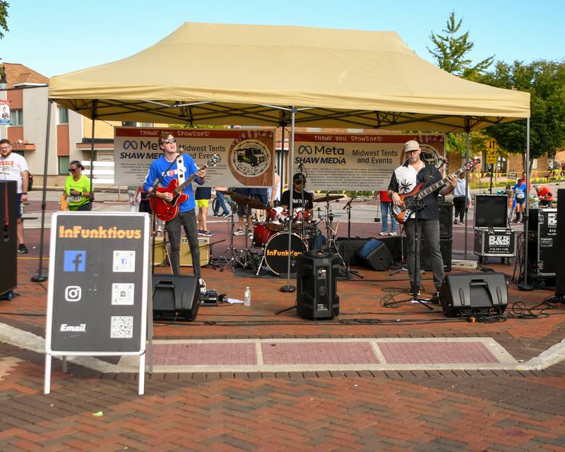 The band InFunktious performs during the Taste Of DeKalb as racers near the finish line in the DeKalb Corn Classic 5K/10K course while others enjoy time with friends, families, food, drinks and live music on Sunday, Sept. 29, 2024, downtown.