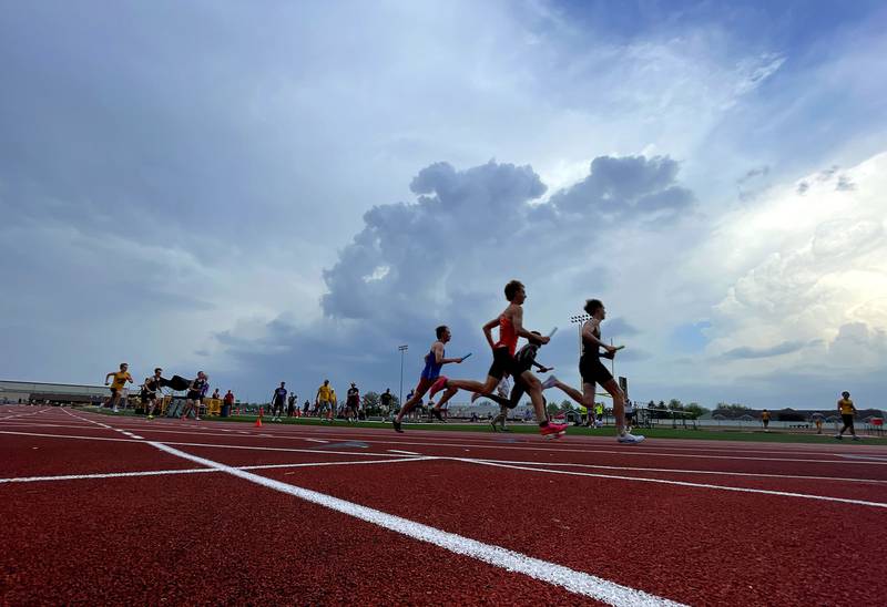 Clouds gather as the 3200-meter relay begins in Fox Valley Conference boys track and field meet action at Huntley High School in Huntley on Thursday, May 15, 2025.