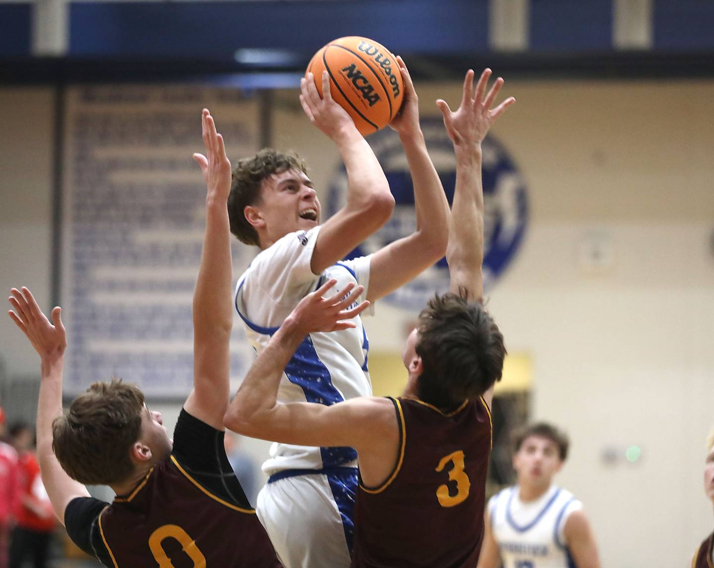 Woodstock's Max Beard (center) shoots the ball between Richmond-Burton's Gavin Radmer (left) and Dane Gardner (right) during a Kishwaukee River Conference boys basketball game on Wednesday, February. 4, 2026, at Woodstock High School.