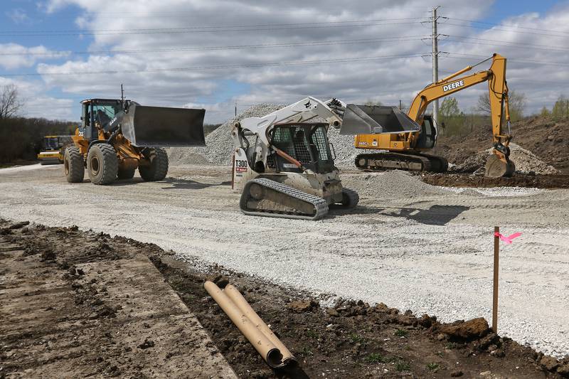 Construction vehicles shuffle around stone as the Fox Waterways Agency builds their Wall Street location on Tuesday, April 13, 2021 in Lake Villa.