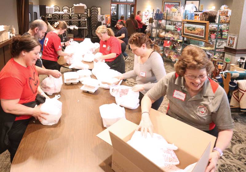 Jessica Kreiser (bottom right), executive director of the Lighted Way, helps package boxes of food for the 27th annual Lighted Way Spaghetti Dinner on Monday, April 20. 2025 at Uptown downtown La Salle.