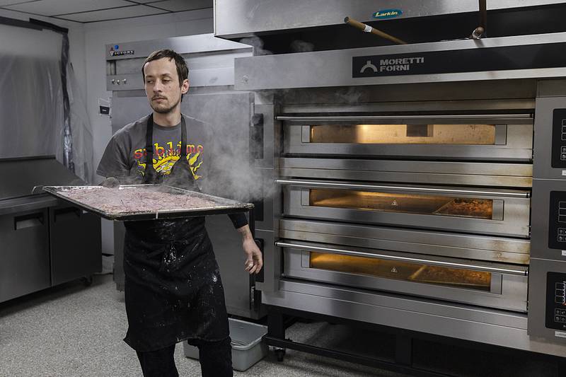 Lena's Social Club's cook Cody Schreiner removes roasted veggies from the oven Friday, Jan. 10, 2025.