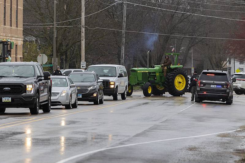 Vehicles turn onto Third Street in Prophetstown Thursday, April 4, 2024 as they make their way to Riverside Cemetery.