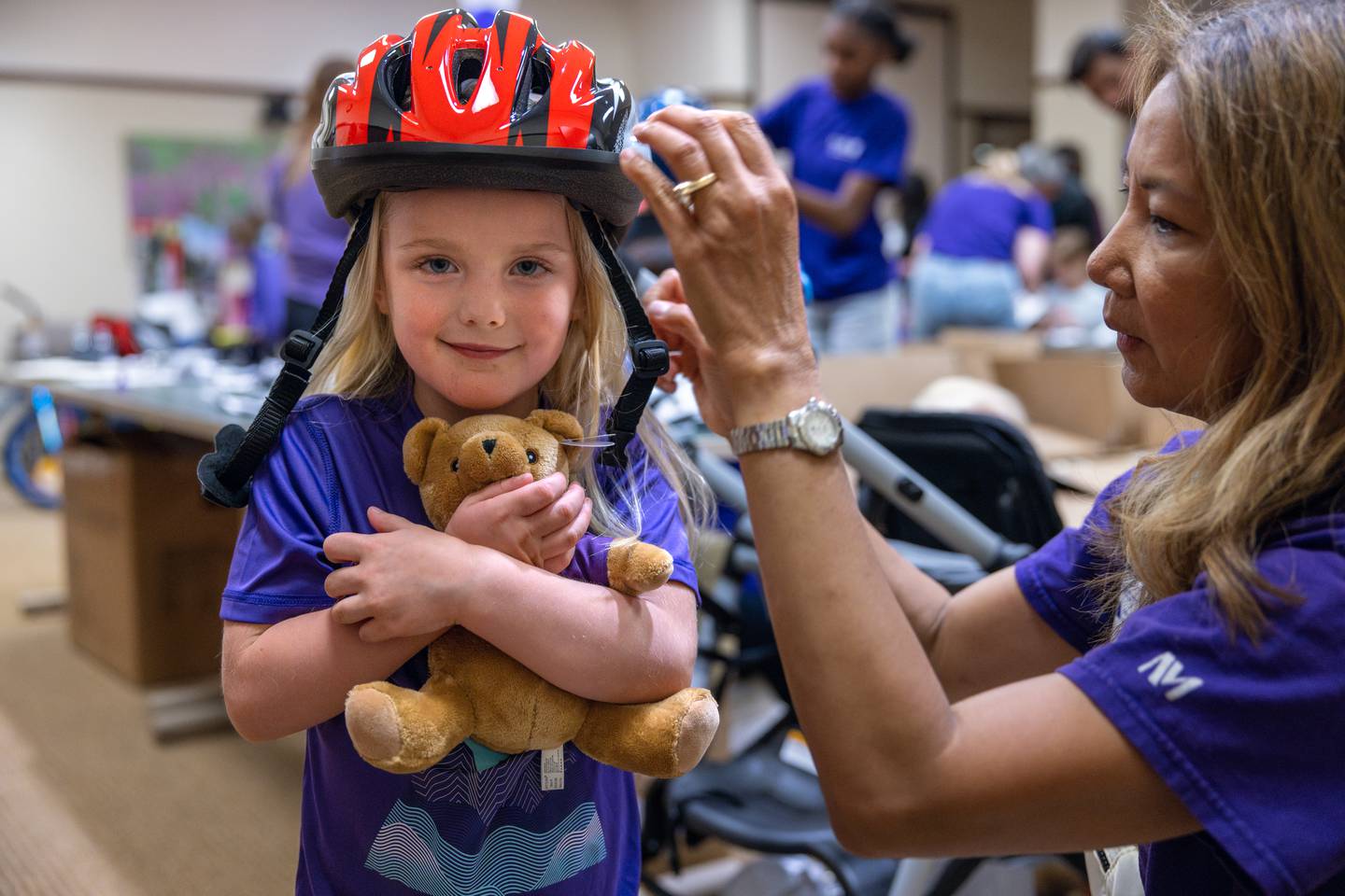 Children lined up for a chance to learn about bike safety, with Northwestern Medicine Grayslake physicians and staff helping to properly fit bike helmets on each child.