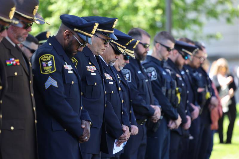 Members of local police departments bow their heads in prayer during the Kankakee County Law Enforcement Memorial on Thursday, May 14, 2026, at the Kankakee County Courthouse.